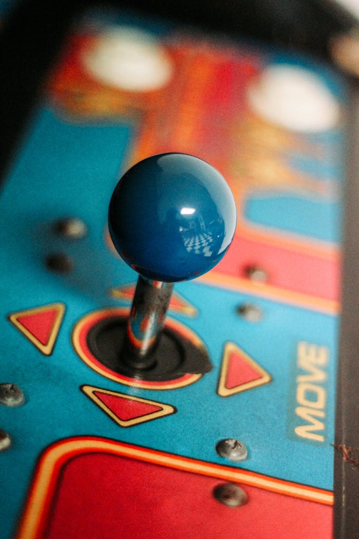 Services Close-up of a vibrant retro arcade joystick showcasing vintage gaming aesthetics with colorful design.